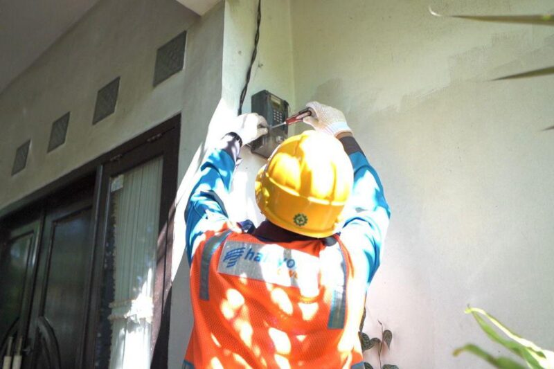 Petugas PLN ketika sedang memeriksa KWH meter di rumah waga.