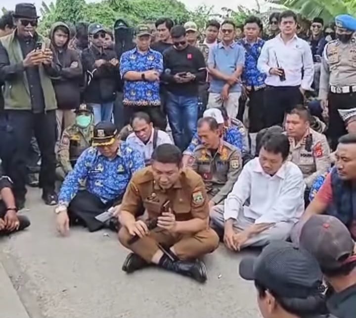 Sekda Banten Deden Apriandhi dan warga Bojonegara-Puloampel saat mendengarkan penjelasan Bupati Serang melalui telepon seluler, Senin 17 November 2025.